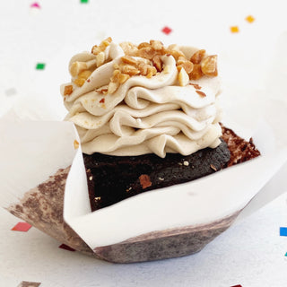Vegan chocolate cupcake topped with vegan peanut butter icing and chopped peanuts.