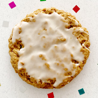 Lightly spiced vegan oatmeal cookie frosted with icing. 