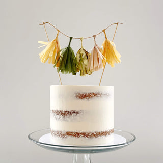 Semi-Naked Cake on a clear cake stand with a tussle cake in orange, green and gold.